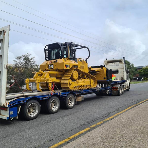 Transporting an earthmoving tractor on a truck for construction projects