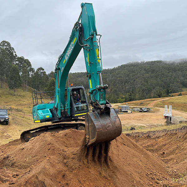 An excavator levelling the ground for a road construction project